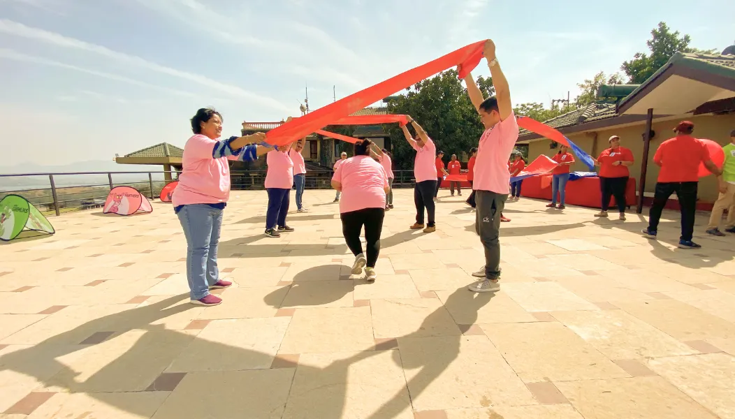 Participants working together in an outdoor team building activity run by HTI Woosh Biz